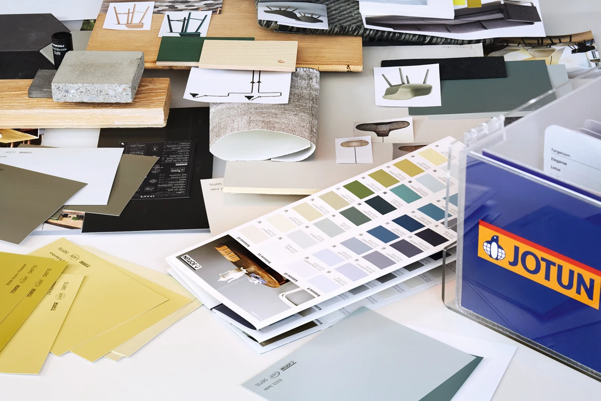 A desk covered with Jotun colour samples