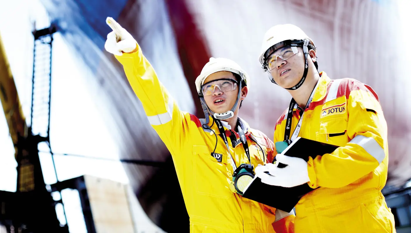 Two engineers, yellow overalls and hard hats
